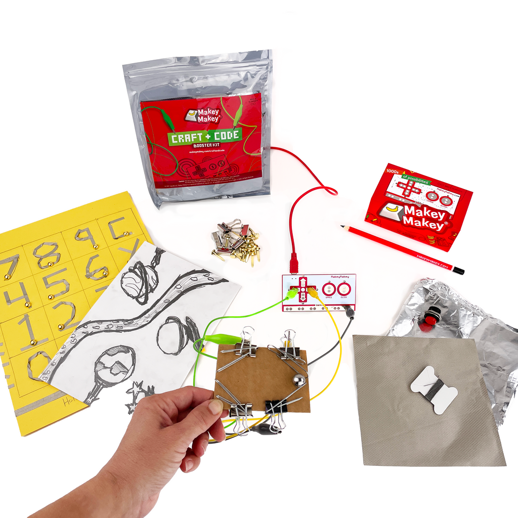 Image of Craft + Code Booster Kit and project ideas, a paper calculator, tilt joystick made with binder clips on cardboard, and some of the supplies are in the background. Conductive thread, foil, conductive fabric, and an arcade button.