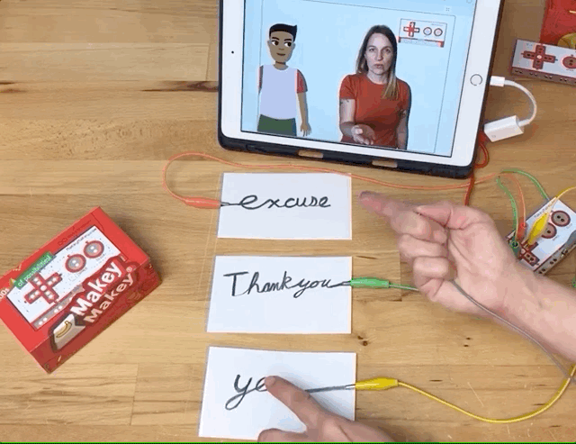 Animated gif of a hand touching a hand drawn word. The touch triggers the Sign in ASL for the word that is touched.